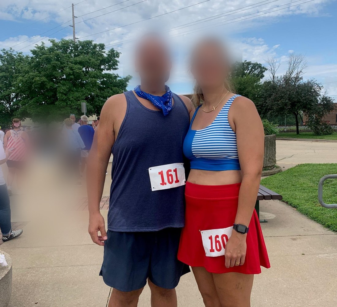 A Buff Muff member and her partner at a 4-mile race, wearing bib numbers, faces obscured