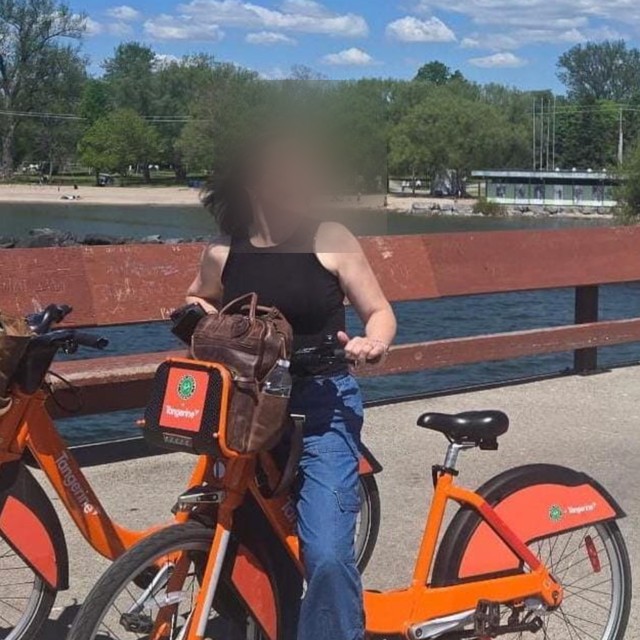 A Buff Muff member out on a bike by the water, face obscured